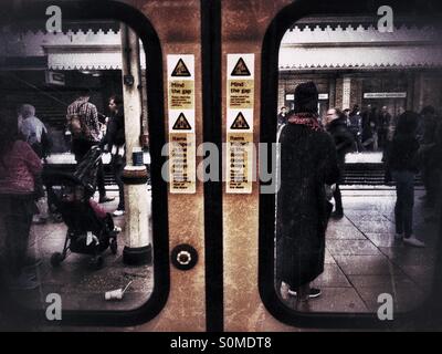 Regardant à travers les vitres de porte sur un train de métro. Banque D'Images