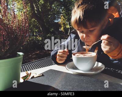 Cinq ans de boire du chocolat chaud à l'extérieur Banque D'Images