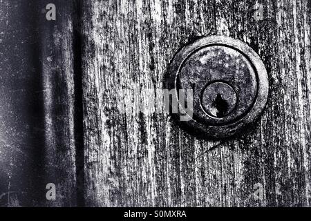Une Union et rouillées serrure de porte sur un groupe d'une granuleuse, porte en bois. Image en noir et blanc. Banque D'Images