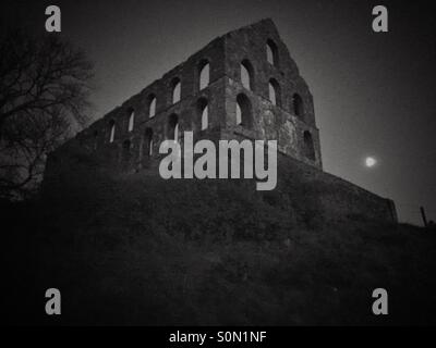 Image en noir et blanc d'un abandon et abandonnés Spooky ancien moulin en ardoise avec la pleine lune à Snowdonia, Nord du Pays de Galles. Banque D'Images