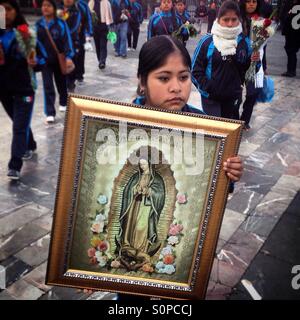 Une jeune femme pilgrim détient une image de Notre Dame de Guadalupe à l'occasion du pèlerinage de Notre Dame de Guadalupe à Mexico, Mexique. Banque D'Images