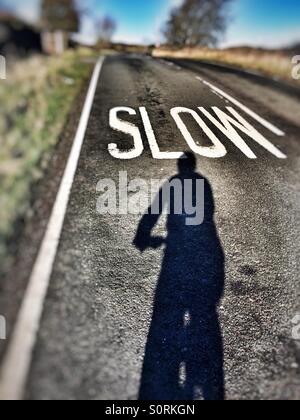 Ombre à l'approche d'un cycliste Selfies lente panneau sur la route Banque D'Images