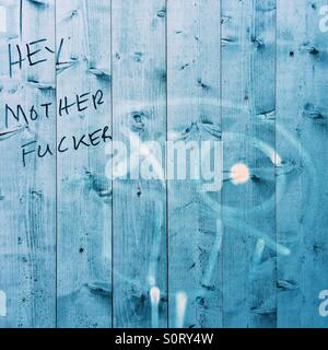 Langage coloré graffiti sur une clôture bleu Banque D'Images