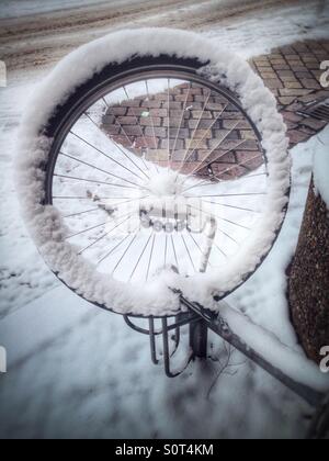 Un vélo volant d'un vélo volé à gauche sur un parking à vélos couvert de neige en rack, Berlin, Allemagne Banque D'Images