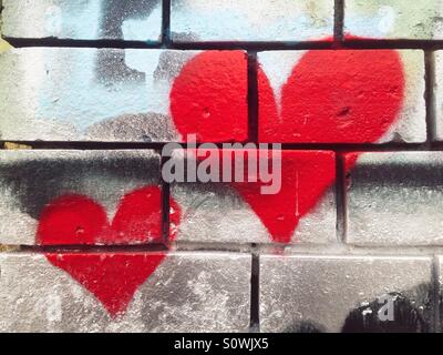 Coeur graffiti sur un mur de briques Banque D'Images