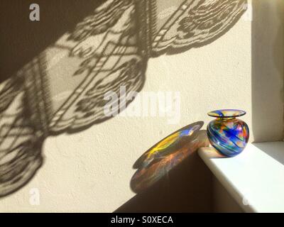 Vase coloré sur un rebord de fenêtre avec la lumière du soleil Casting Shadows. Banque D'Images