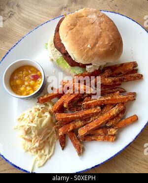 Vegetable burger servi sur un livre blanc bap avec frites de patates douces, maïs et salade de plaisir Banque D'Images