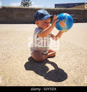 Enfant jouant avec globe ball Banque D'Images