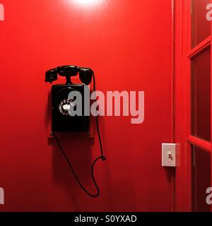 Téléphone vintage on red wall Banque D'Images