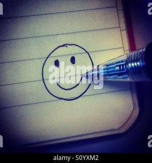 Dessiner un smiley dans le coin d'un booknote avec un crayon Banque D'Images