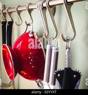 Des ustensiles de cuisine sur des crochets de suspension dans une cuisine Banque D'Images