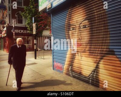 Plus l'homme à Chypre, Harringay Green lanes. En passant par la boutique avec un portrait de femme peint sur ses volets. Londres, R.-U. Banque D'Images