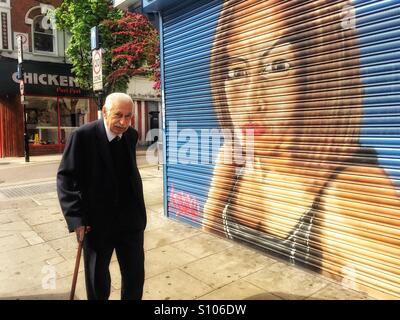 Plus l'homme à Chypre, Harringay Green lanes. En passant par la boutique avec un portrait de femme peint sur ses volets. Londres, R.-U. Banque D'Images