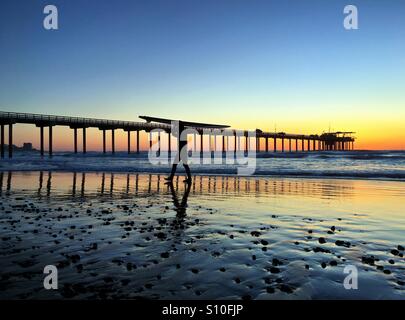 Porte un surfeur surf sur la tête après une journée de surf à La Jolla, Californie, USA Banque D'Images