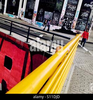 Bogotá les piétons à pied autour de l'angle de la rue, couverts de manière aléatoire griffonne et territoire tags, à Santa Fé, Bogota, Colombie, 17 février, 2016. Banque D'Images