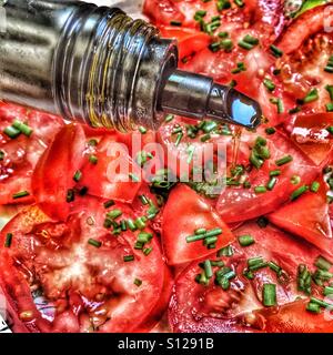 Un filet d'huile d'olive sur la salade de tomates Banque D'Images