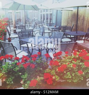 Plus de parapluies patio extérieur salle à manger du restaurant, entouré de géraniums rouges. Stratford-upon-Avon, Warwickshire, Angleterre, Royaume-Uni. Banque D'Images