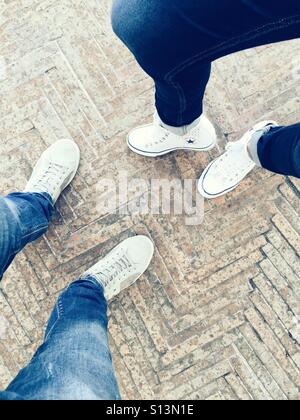 Vue de dessus de l'homme et de la femme marchant côte à côte en Jeans et Sneakers blanches Banque D'Images