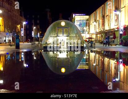 La station de métro St Enoch, Glasgow, Écosse reflète dans une piscine de l'eau la nuit. Banque D'Images