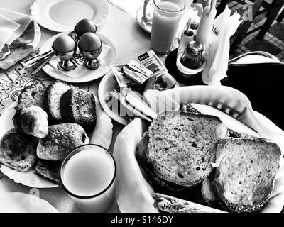Un hôtel petit-déjeuner avec des œufs, du pain, des viennoiseries et du jus d'orange. Banque D'Images