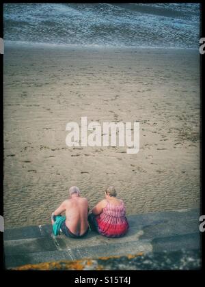 Couple d'âge moyen sur une plage anglaise Banque D'Images