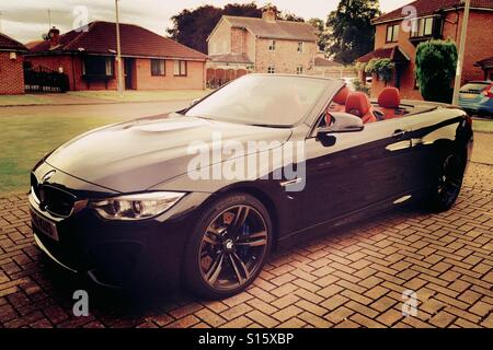 BMW M4 voiture sport décapotable garée dans l'entraînement de la chambre urbaine Banque D'Images