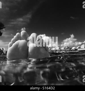 Les pieds d'une femme flottant dans la piscine. Maui, Hawaii. Banque D'Images