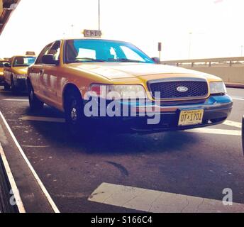 Ford Crown Victoria taxi jaune et de l'aéroport JFK de New York. Pendant des années, la Crown Vic a été le taxi de choix, souvent ex-voitures de police, mais est en train de disparaître au profit d'hybrides Banque D'Images