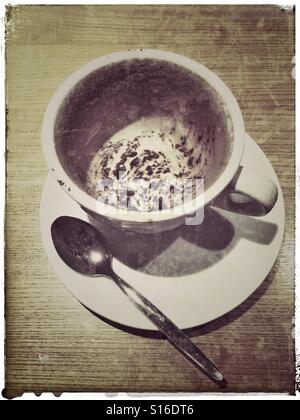 Un passage photo d'une tasse vide de Cappuccino boisson. Une cuillère sale se trouve sur la soucoupe, à côté de la tasse. Crédits photos - © COLIN HOSKINS. Banque D'Images