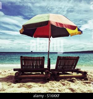 Fauteuils en bambou sous parapluie de plage sur une plage de Plage de Puka, Boracay Island, Philippines Banque D'Images