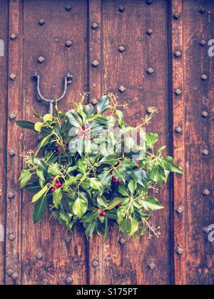 Couronne de Noël accroché sur la porte en bois Photo Stock - Alamy