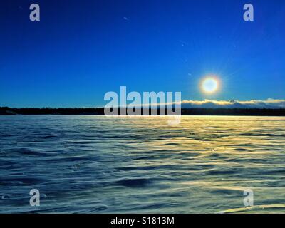 La neige et les amoncellements de neige sur un lac gelé en décembre au coucher du soleil montrant dimanche et quelques étoiles. Calgary, Alberta, Canada Banque D'Images