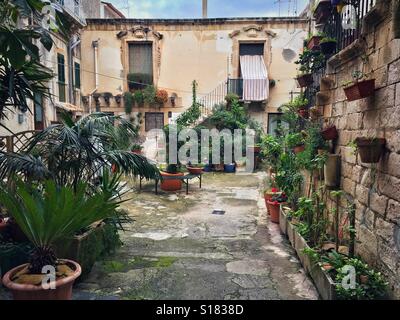 Cour pleine de plantes sur l'île d'Ortygie, partie historique de la ville de Syracuse, Sicile, Italie Banque D'Images