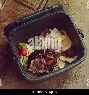 Les déchets alimentaires bac à compost sur patio sous la pluie. Banque D'Images