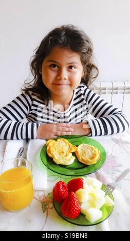 Petite fille avec petit-déjeuner. Banque D'Images