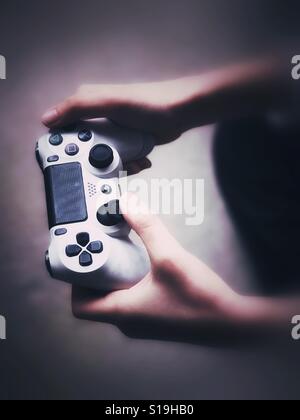 Tenant une manette de PlayStation Banque D'Images