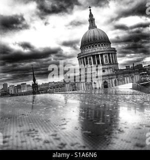 Photo en noir et blanc de Saint Paul's Cathedral reflétée sur un toit de pluie sous un ciel dramatique à Londres, Angleterre, Royaume-Uni. Banque D'Images