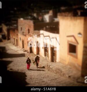 Les femmes passent devant chez eux jusqu'à la place principale dans la région de Real de Catorce, San Luis Potosi, au Mexique. Banque D'Images