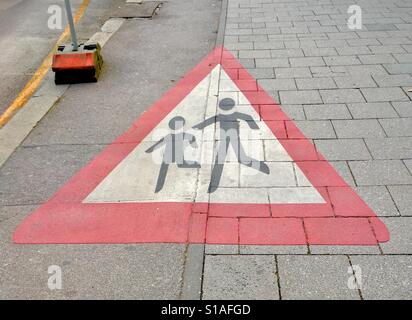 Enfants traversant Grand panneau routier peint sur le chemin. Munich, Allemagne Banque D'Images