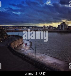 Un couple en train de marcher sur la promenade autour du lac marin, Weston super Mare, North Somerset, Angleterre Banque D'Images