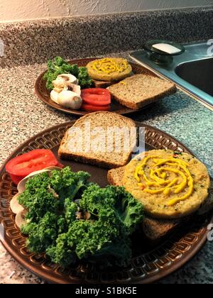 Veggie Burgers sur du pain avec du jaune moutarde, le chou, les champignons et les tomates. Banque D'Images