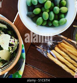 Olives vertes et bâtonnets de pain sur la table Banque D'Images