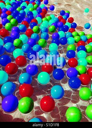 Billes en plastique coloré flottant sur l'eau Banque D'Images