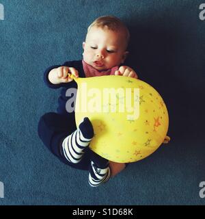 Bébé Garçon jouant avec un ballon jaune Banque D'Images