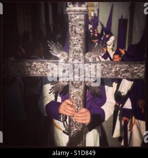 Semaine sainte croix porte pénitent lors d'une procession de Pâques à Baeza, ville andalouse dans le sud de l'Espagne. Banque D'Images