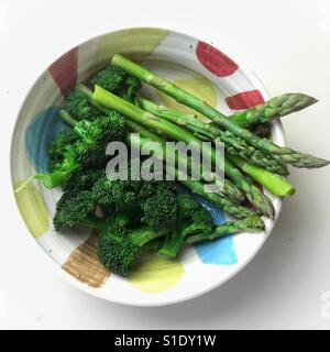 Asperges cuites à la vapeur et du brocoli au Bol en céramique fait main Banque D'Images