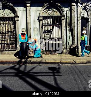 Les éboueurs salvadorien travail en avant d'une maison en ruine, conçu à l'aide d'éléments de l'architecture coloniale espagnole audacieux, construit dans le centre de San Salvador, El Salvador, 10 novembre 2016. Banque D'Images