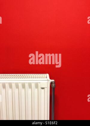Radiateur blanc sur un mur rouge Banque D'Images