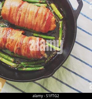 Filet de porc enveloppé de Bacon dans une poêle en fonte aux asperges Banque D'Images