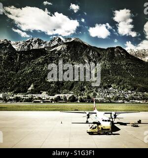 Avion prêt à décoller d'un aéroport avec un chariot à l'avant. Contexte de la montagne et de la vieille ville Banque D'Images